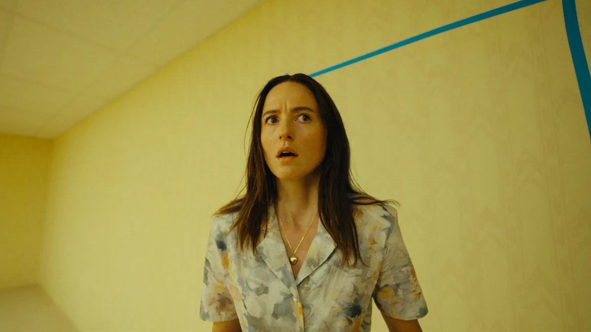 Backrooms filmi liminal mekan sahnesi: sarı duvarlı, ışıkları vızıldayan sonsuz boş koridor