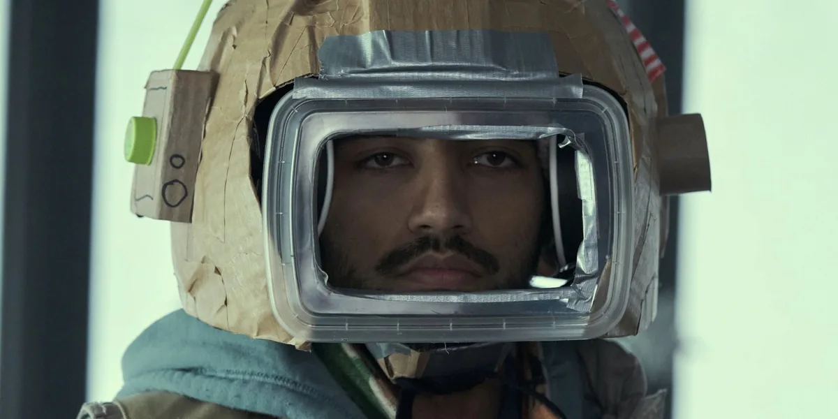 Station Eleven dizisinden resmi sahne: Gezgin Senfoni oyuncusu, tiyatro topluluğunun post-apokaliptik dünyada sergilediği karton astronot kostümüyle