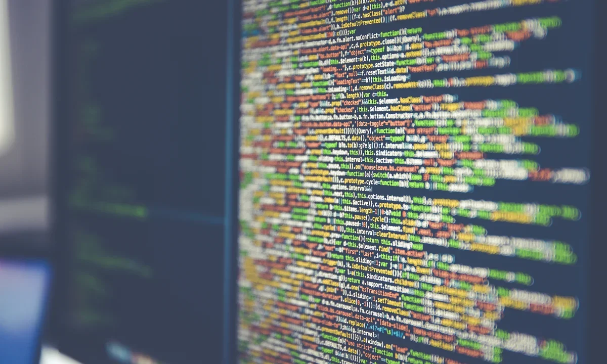 Karanlık bir ekranda akan renkli, kriptik programlama kodu satırları — unutulmuş ve ezoterik programlama dilleri temasını temsil eden görsel