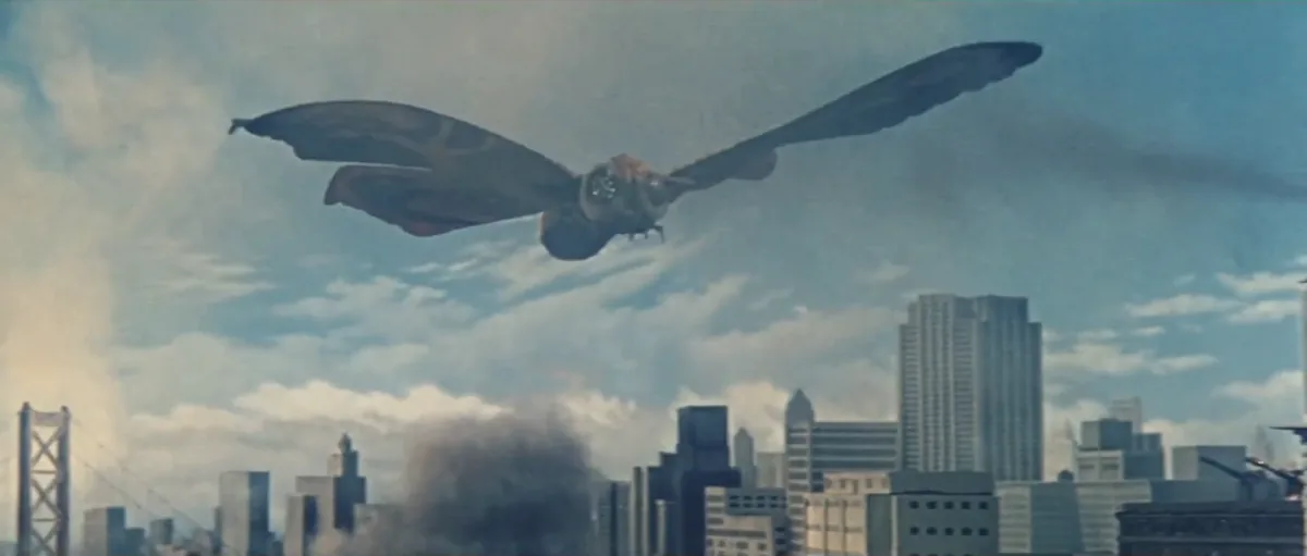 Mothra filminin resmi fragman karesi; dev kanatlı güve kaijusu Mothra şehir üzerinde uçarken