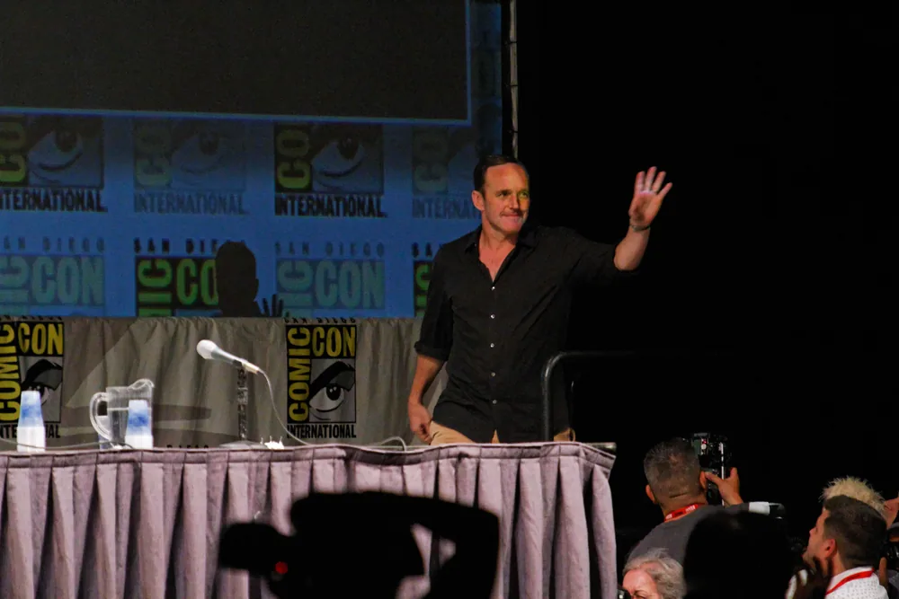 Ajan Phil Coulson karakterini canlandıran oyuncu Clark Gregg 2010 Comic-Con sahnesinde el sallıyor