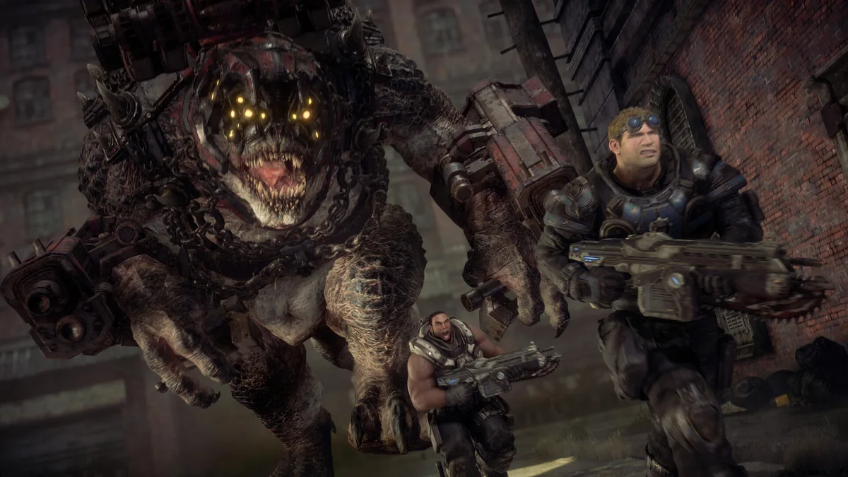 Gears of War oyununda COG zırhlı Marcus Fenix ve ekibi, Lancer zincirli testereli tüfekleriyle devasa bir düşmana karşı duruyor