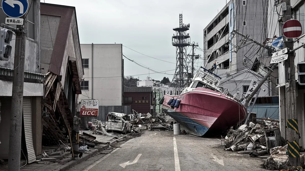 2011 Japonya tsunamisinin yol açtığı yıkım: Tōhoku kıyısında bir sokağa sürüklenmiş balıkçı teknesi ve enkaz