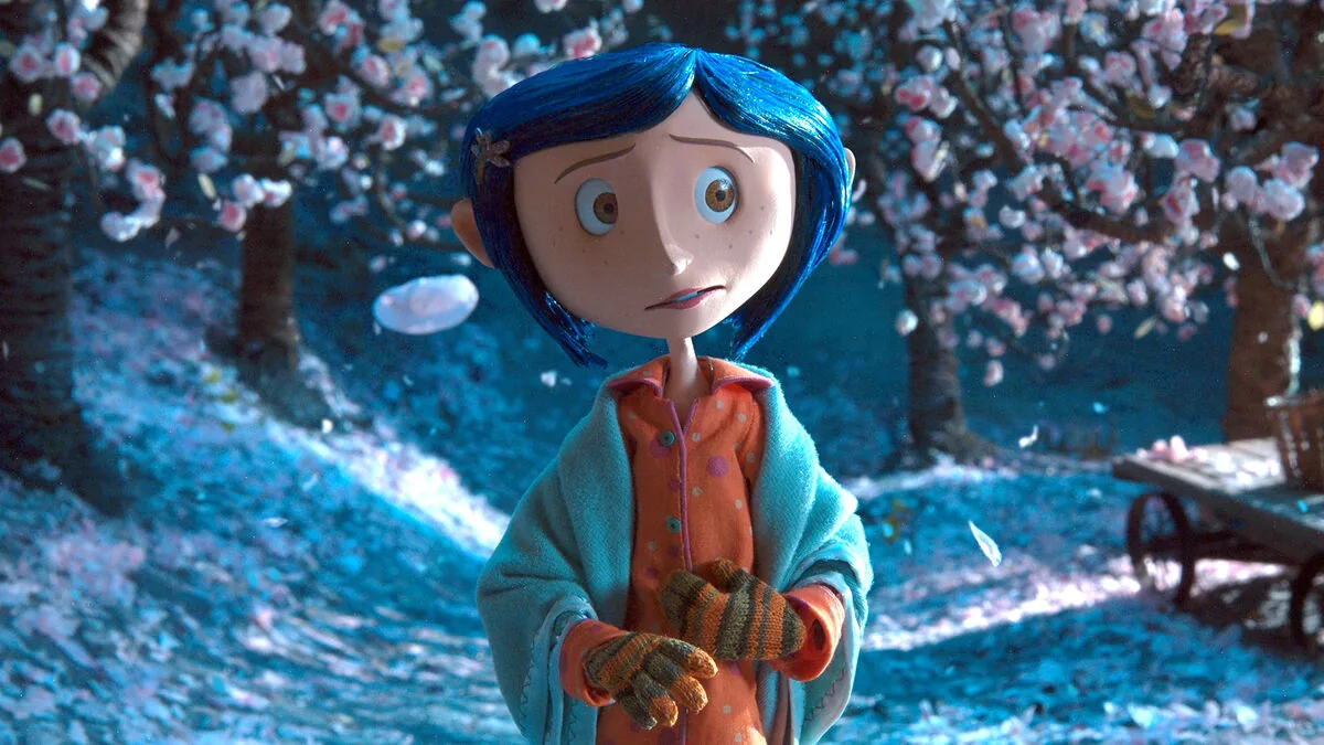 Coraline filminde mavi saçlı Coraline, kiraz çiçeği ağaçlarının arasında düğmeli gözlerle