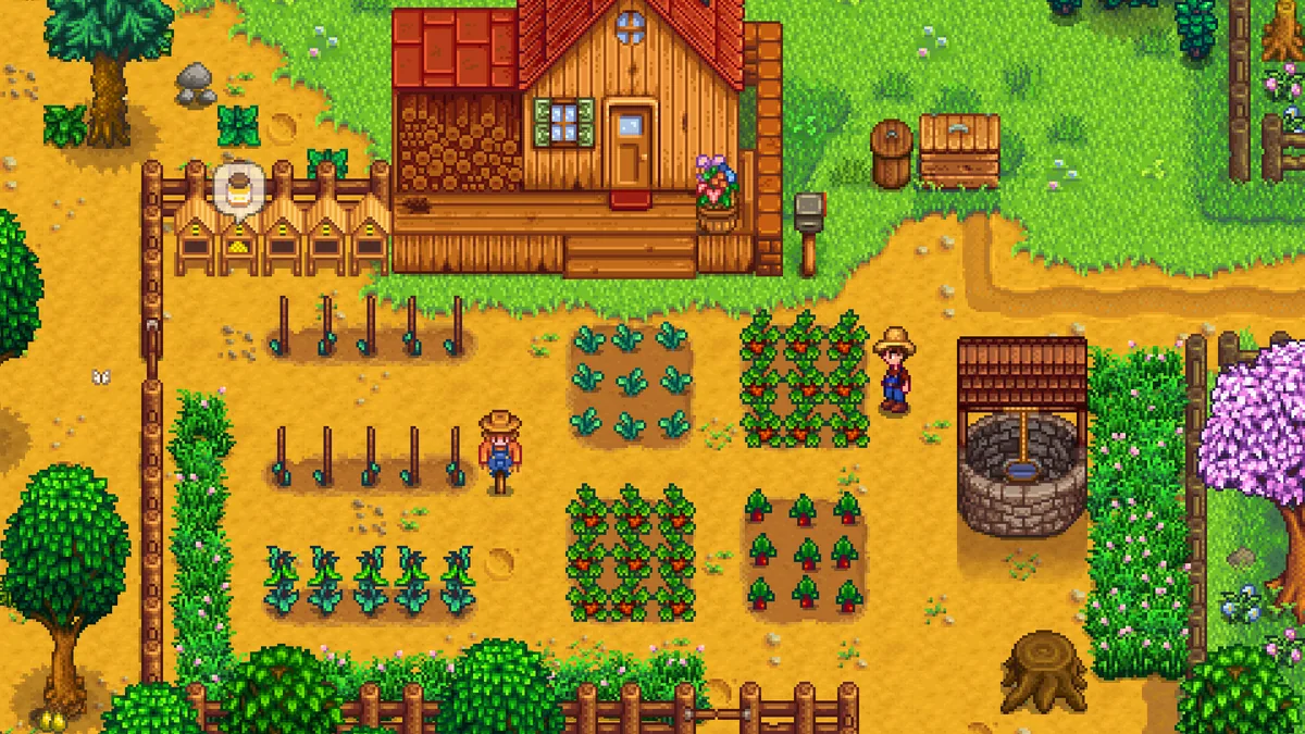 Stardew Valley oyununda çiçek açan kiraz ağacı ve kuyu ile bahar bahçesinde çalışan pixel-art çiftçi karakteri