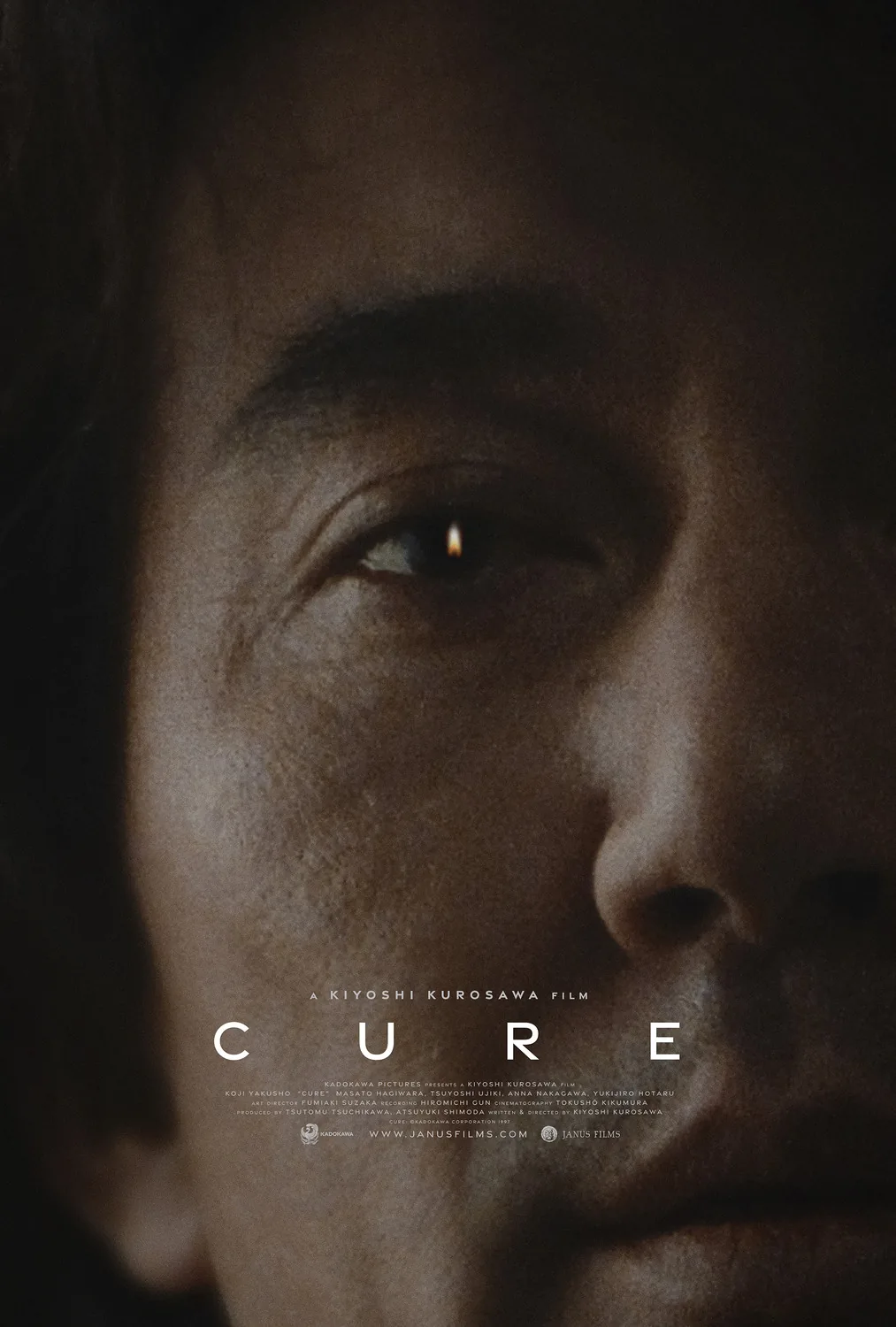 Cure (1997) filminin resmi afişi; Kiyoshi Kurosawa'nın yönettiği Japon psikolojik gerilim filminden karanlık bir yüz kompozisyonu