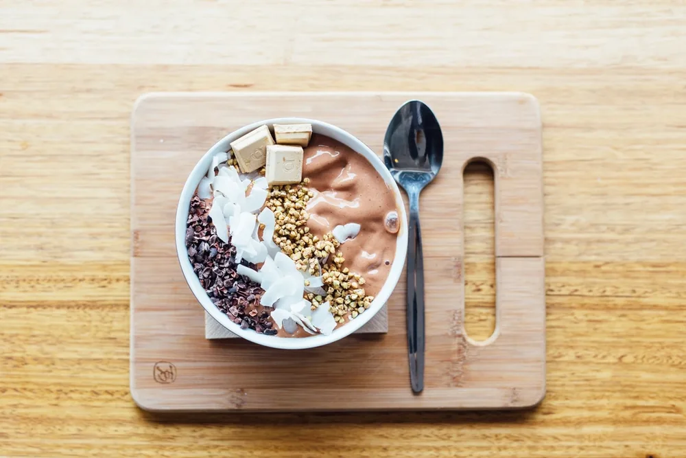 Dengeli bir öğün kâsesi: meyve, fındık ve tahıllarla hazırlanmış sağlıklı smoothie bowl