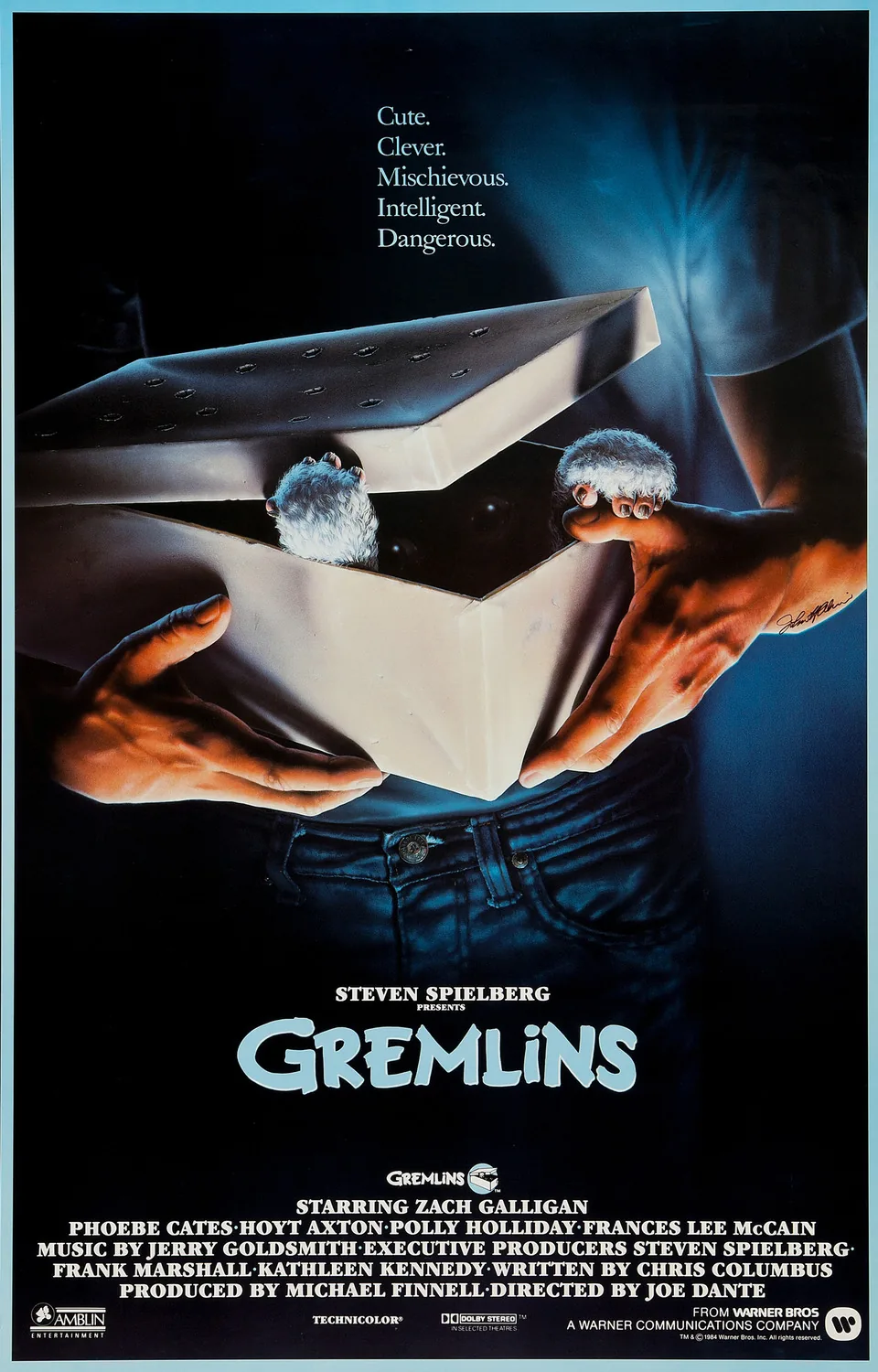 Gremlins (1984) filminin resmî afişi, kutudan çıkan mogwai yaratıklarını gösteriyor, Steven Spielberg'in yapımcılığını üstlendiği film