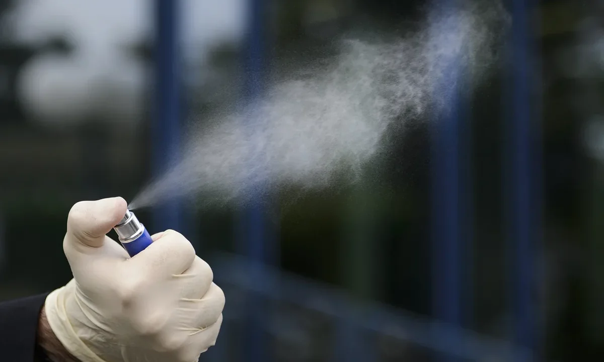 Eldivenli bir el hemostatik sprey veya toz uygularken yakın plandan görülüyor