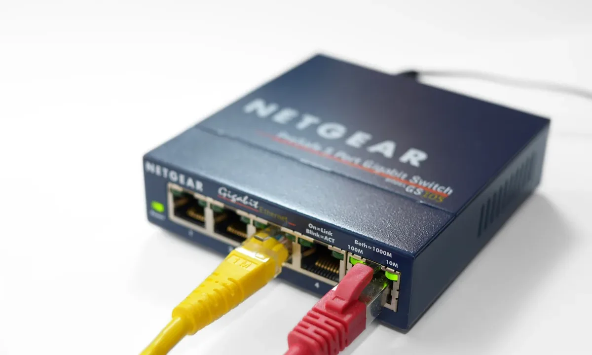 Gigabit Ethernet portlu modern bir ağ switch'i ve takılı Ethernet kabloları