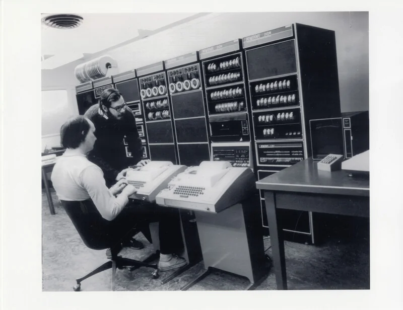 Ken Thompson (oturan) ve Dennis Ritchie (ayakta), Bell Labs'ta bir PDP-11 bilgisayarı başında