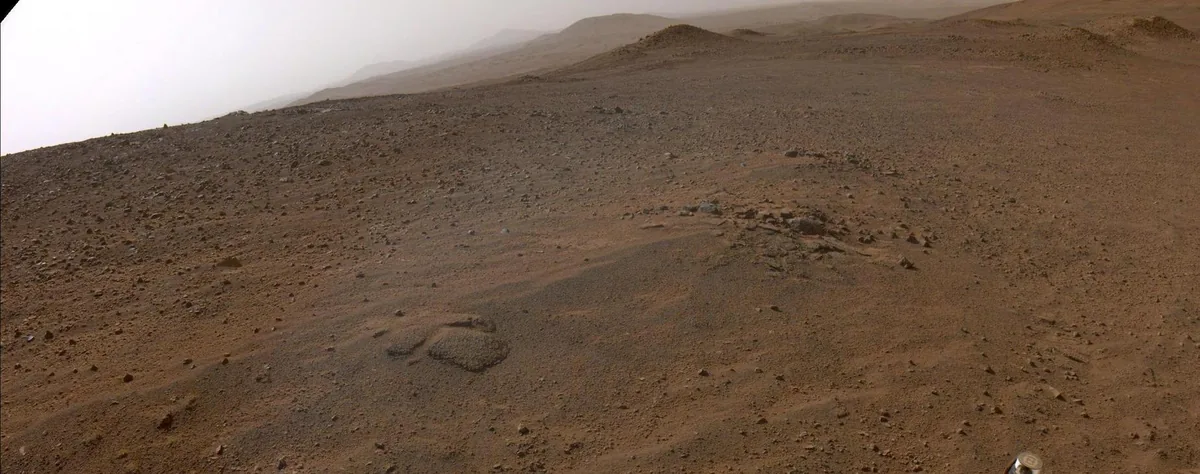 Mars yüzeyinin gerçek görünümü: kızıl-turuncu tozlu çöl ve pembemsi puslu gökyüzü (NASA Perseverance)