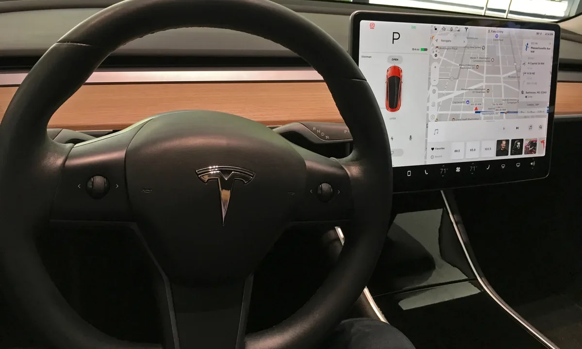 Elektrikli lüks bir otomobilin direksiyonu ve merkez dokunmatik ekranı; otomobillerde özellik abonelik modelinin sembolü olan dijital arayüz