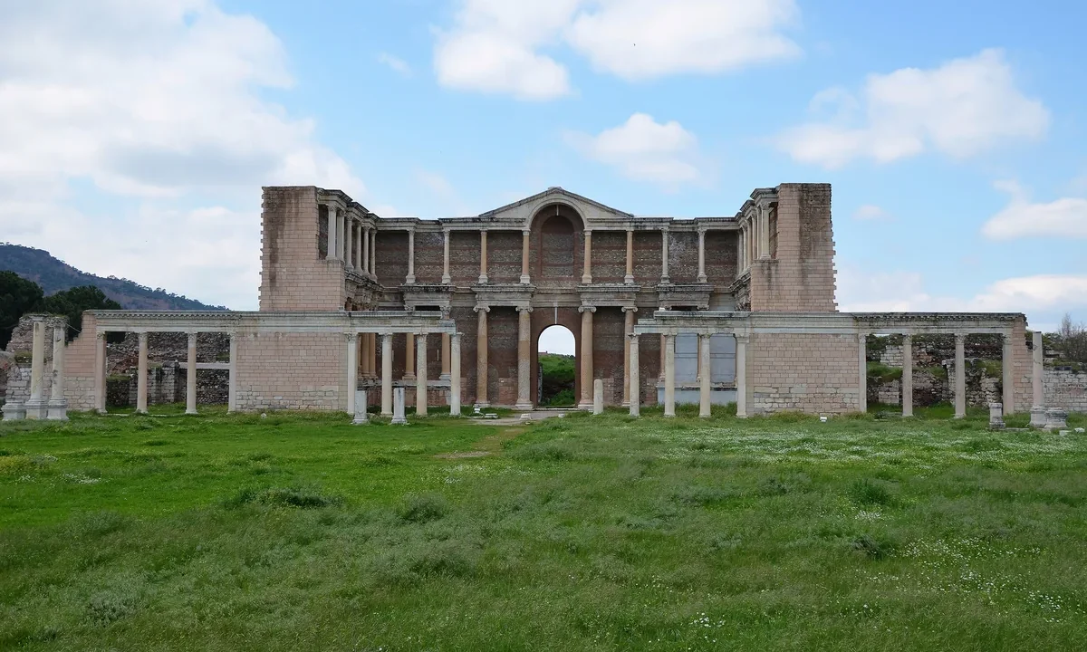 Sardis Gymnasium-Hamam Marble Court'un restore edilmiş mermer sütunlu görkemli cephesi, mavi gökyüzü altında