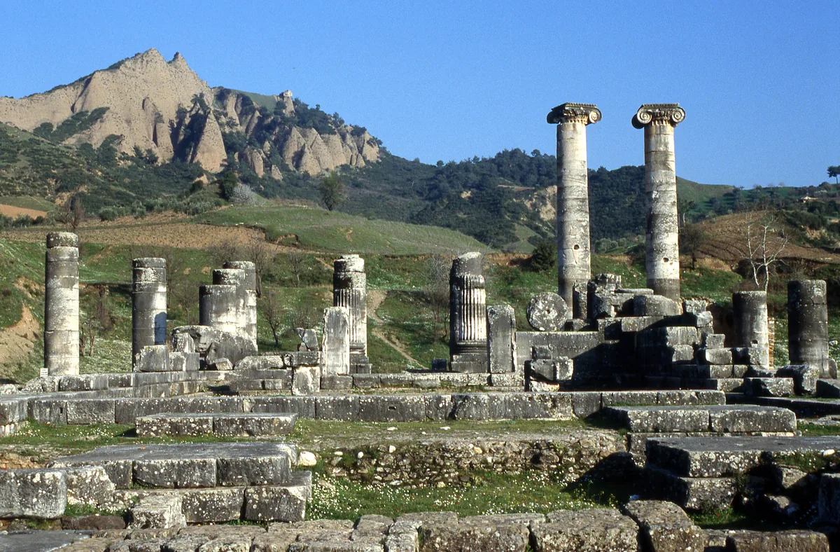 Sardis Artemis Tapınağı'nın ayakta kalan İyon sütunları ve arkada Akropolis tepesi