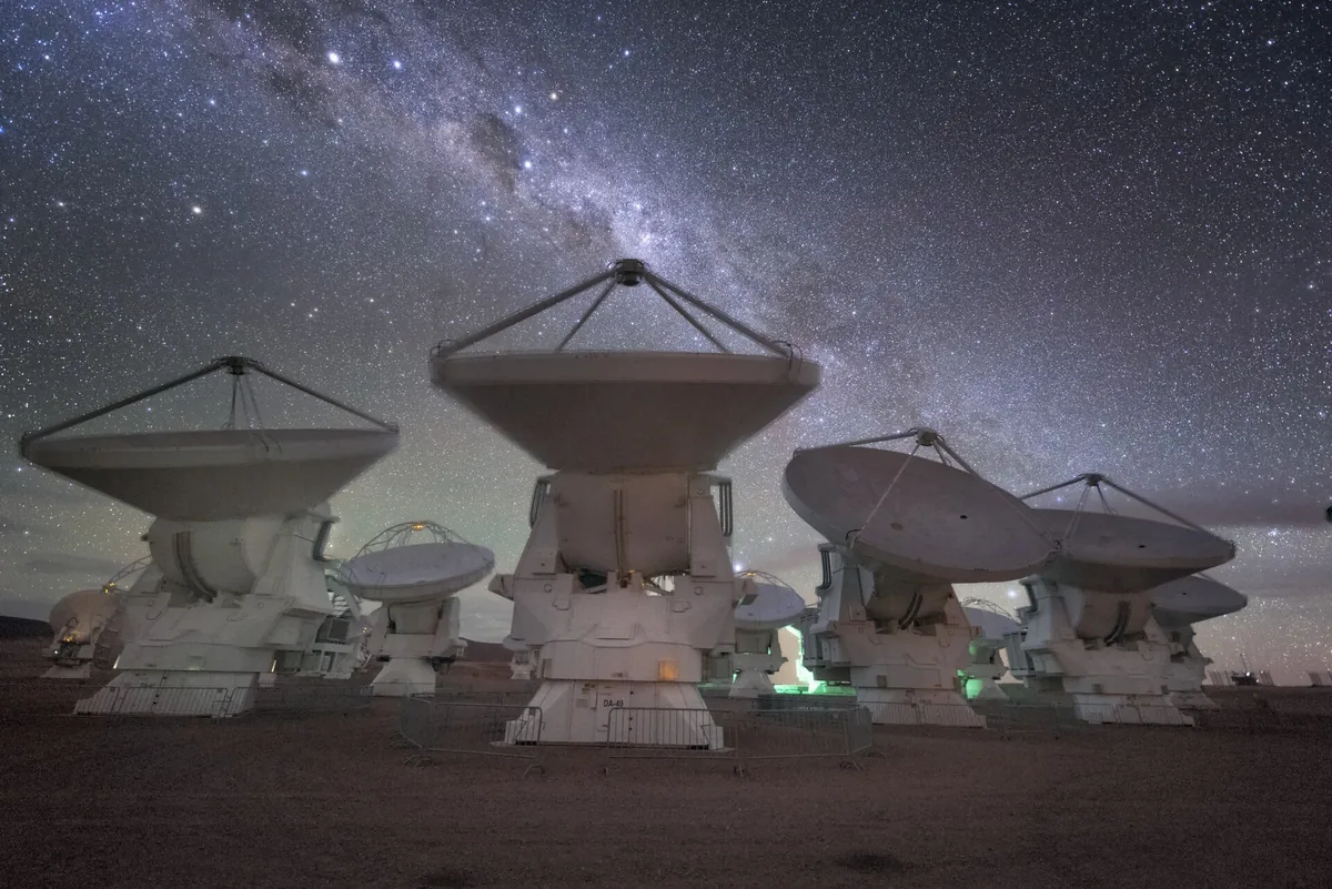 Gece Samanyolu altında yıldızlara dönük radyo teleskop antenleri dizisi; SETI ve teknoimza arayışını simgeliyor