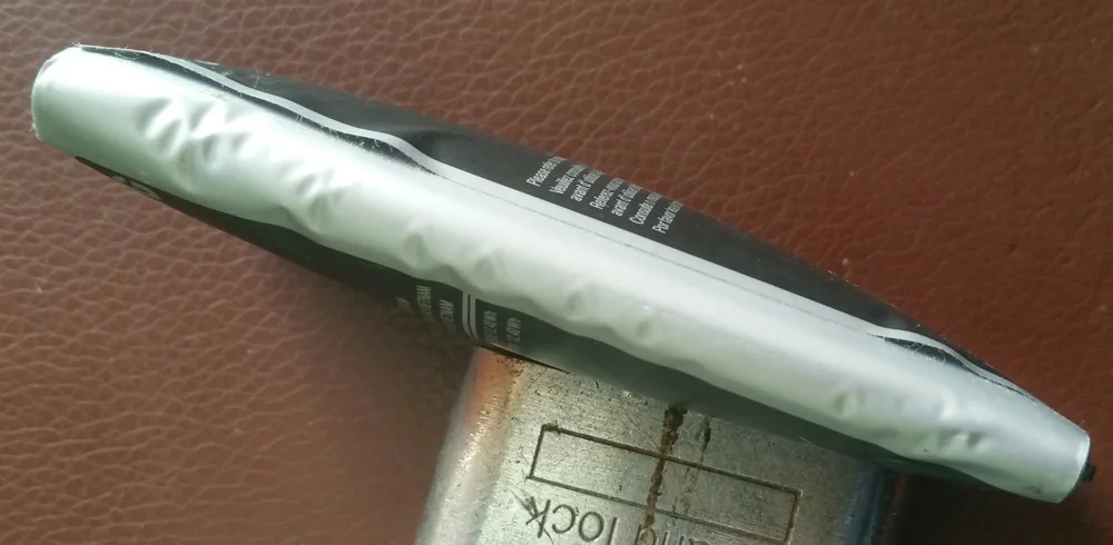 Şişmiş, kabarmış bir lityum iyon telefon pili; pil arızası ve sızıntı tehlikesinin görsel kanıtı