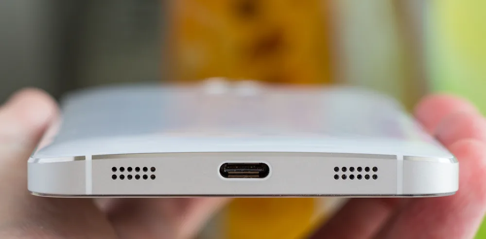 Akıllı telefonun şarj portu yakın çekim; portta biriken toz ve tüy ısındığında hafif koku yapabilir