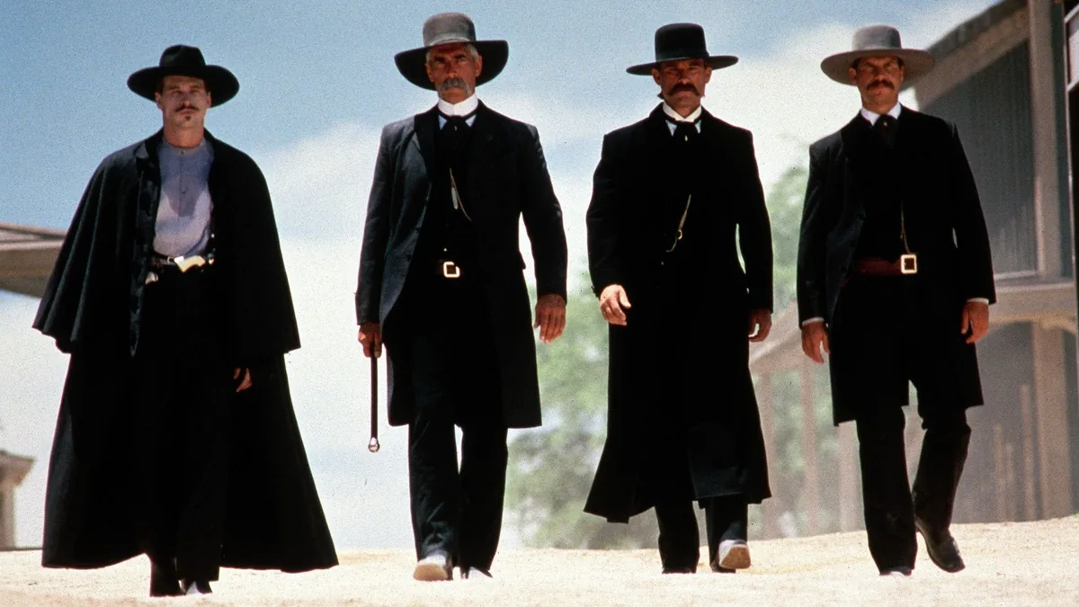 Tombstone filminde Earp kardeşler ve Doc Holliday kasaba sokağında birlikte yürürken, western kostümleri ve şapkalarıyla