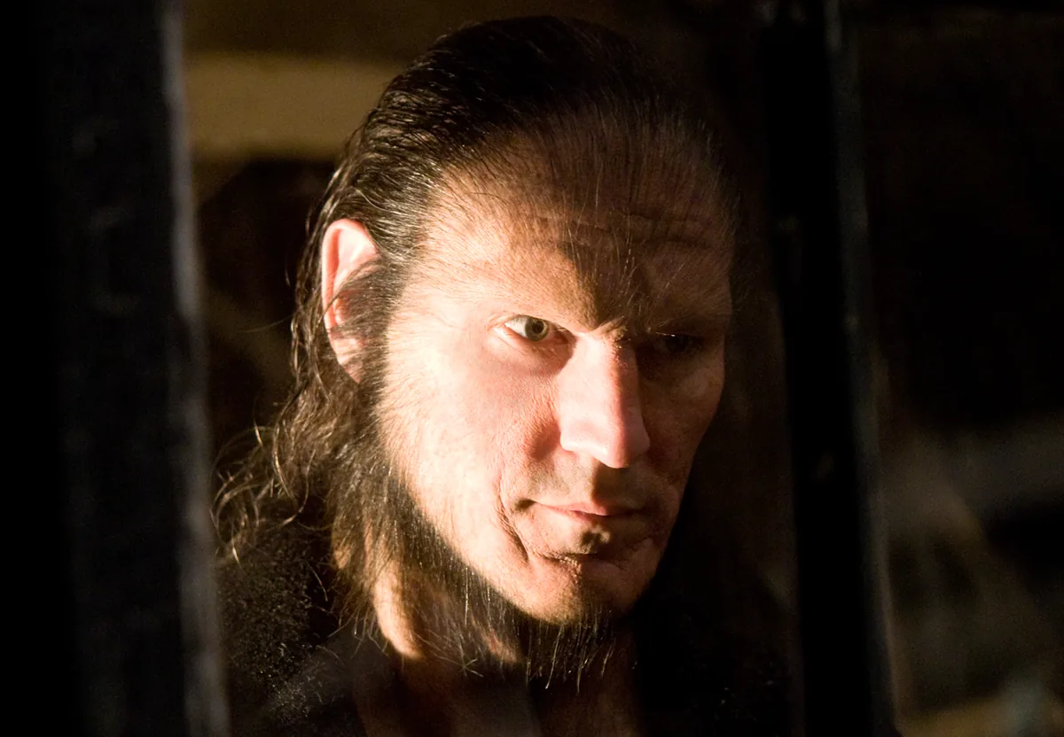 Fenrir Greyback'in yaralı yüzü ve vahşi bakışıyla karanlıkta resmi film görüntüsü
