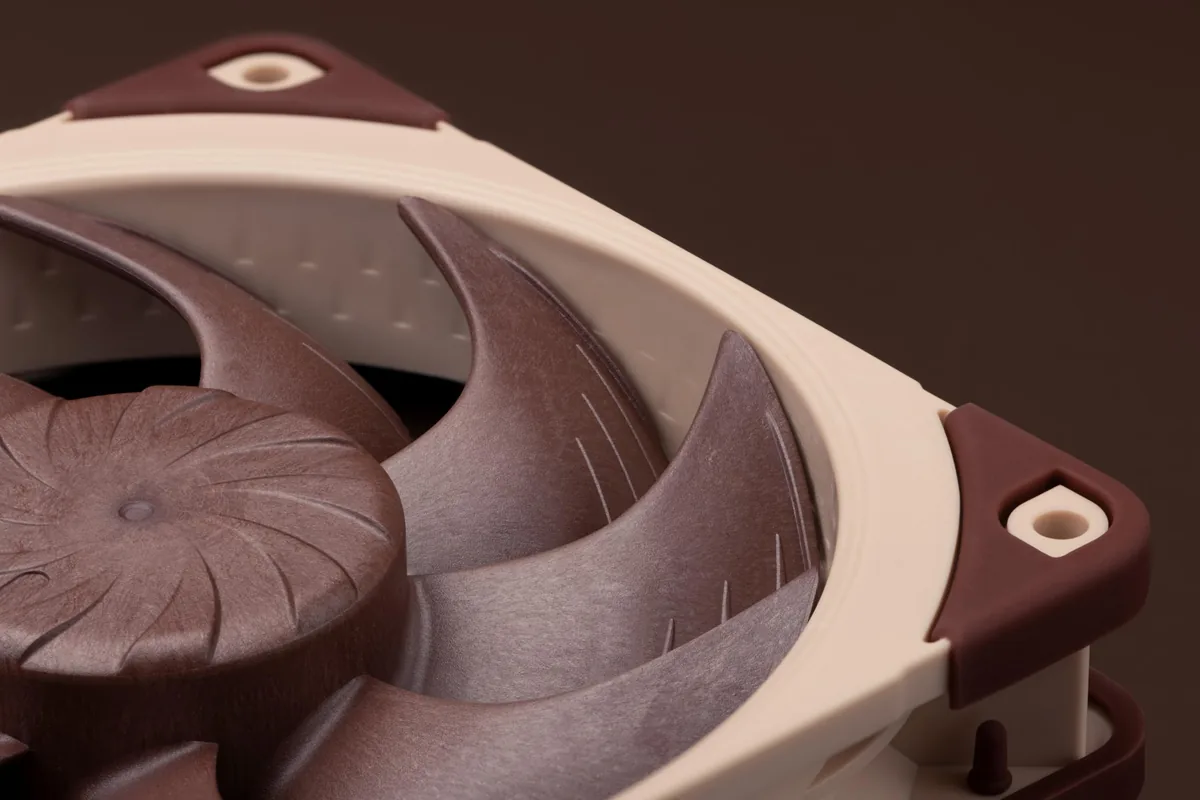 Noctua fan pervanesinin makro çekimi; kanat ucu boşluğu, çerçeve köşesindeki titreşim yastığı ve kanat geometrisi yakından görünüyor