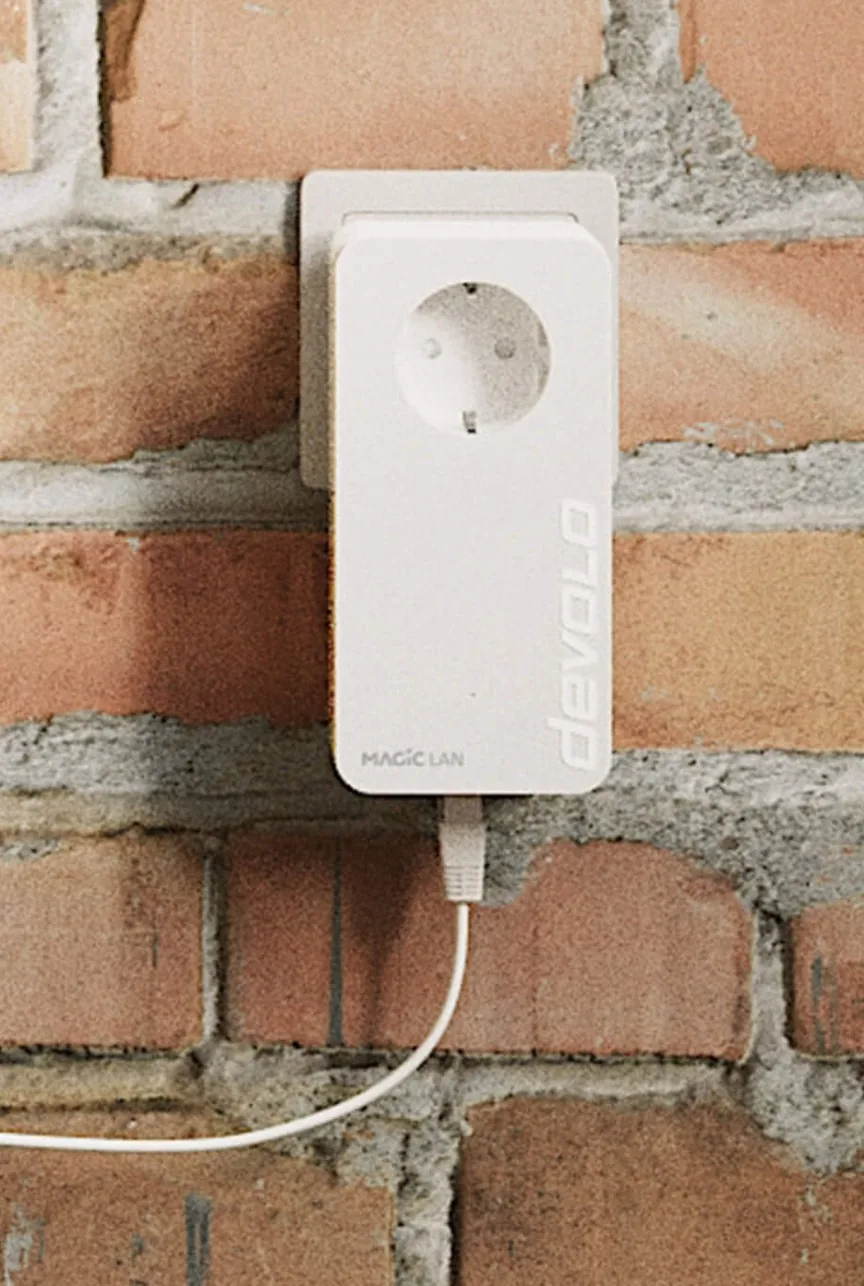 Powerline adaptörün duvardaki elektrik prizine doğrudan takılı hali ve ucuna bağlı Ethernet kablosu